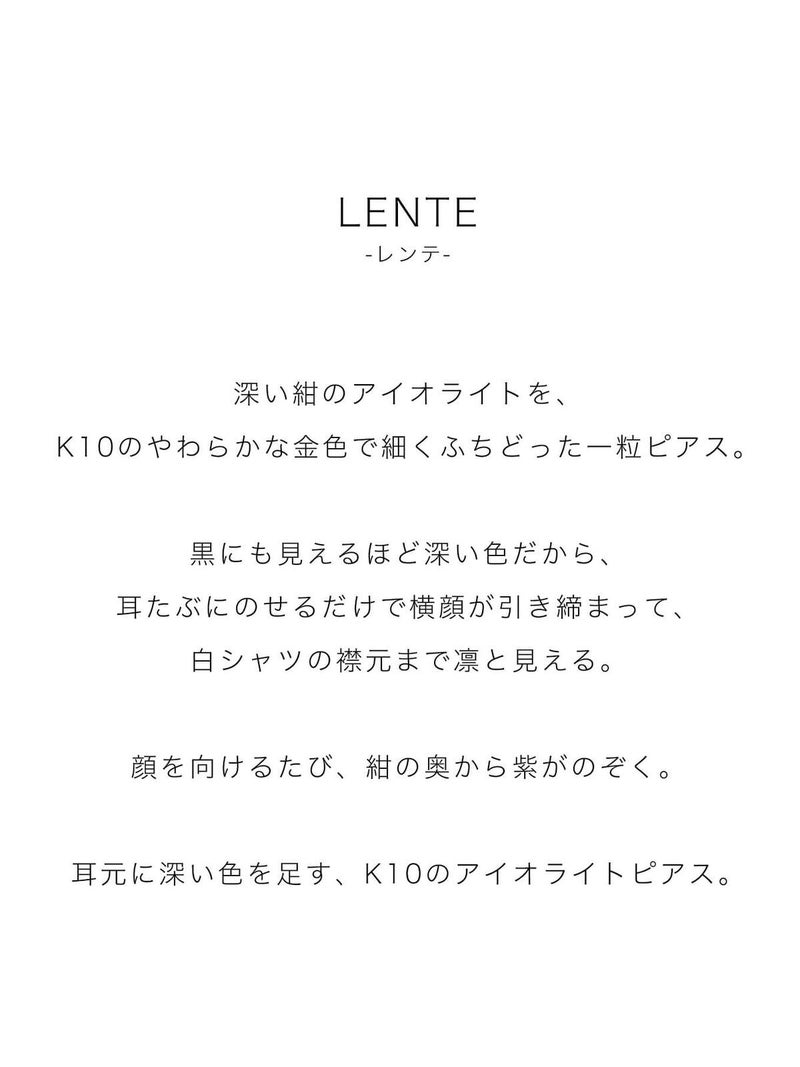 深い紺のアイオライトを、K10のやわらかな金色で細くふちどった一粒ピアス。黒にも見えるほど深い色だから、耳たぶにのせるだけで横顔が引き締まって、白シャツの襟元まで凛と見える。顔を向けるたび、紺の奥から紫がのぞく。耳元に深い色を足す、K10のアイオライトピアス。